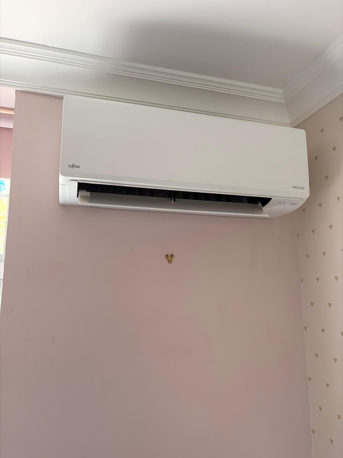 Fujitsu wall-mounted air conditioning unit installed in a bedroom